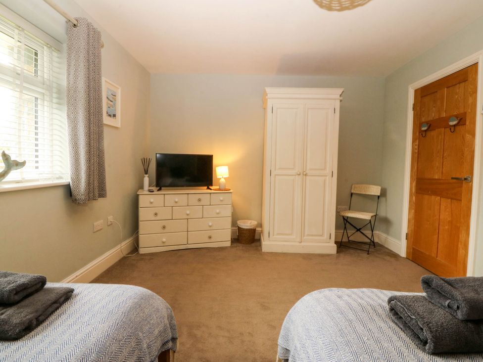 A bedroom with two beds and a television at Ty Ni Dyffryn Ardudwy