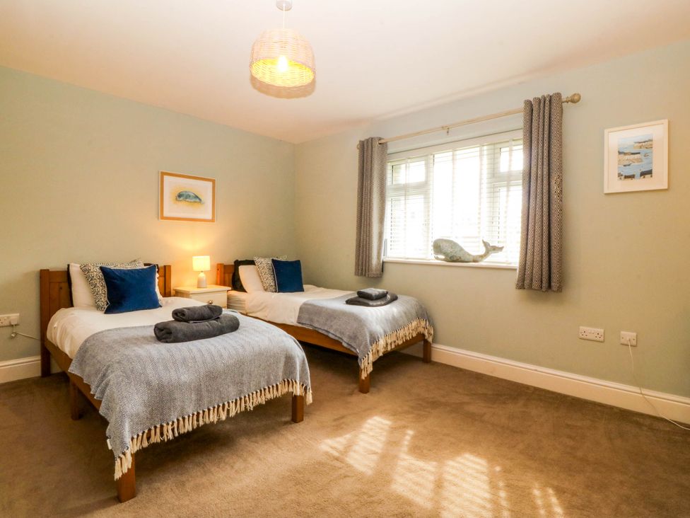 A bedroom with twin beds and artwork at Ty Ni in Dyffryn Ardudwy