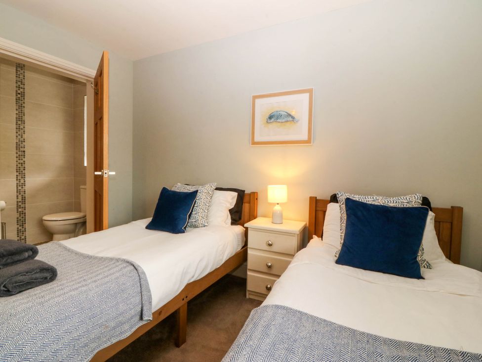 A bedroom with two beds and a nightstand at Ty Ni in Dyffryn Ardudwy