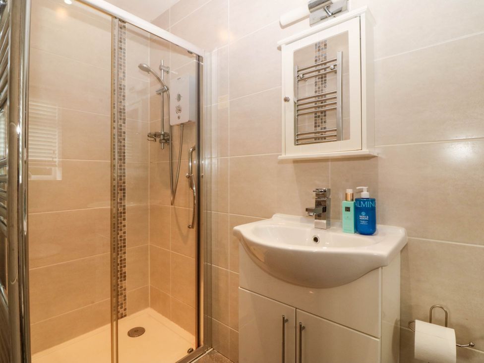 A bathroom with a shower and wash basin at Ty Ni Dyffryn Ardudwy