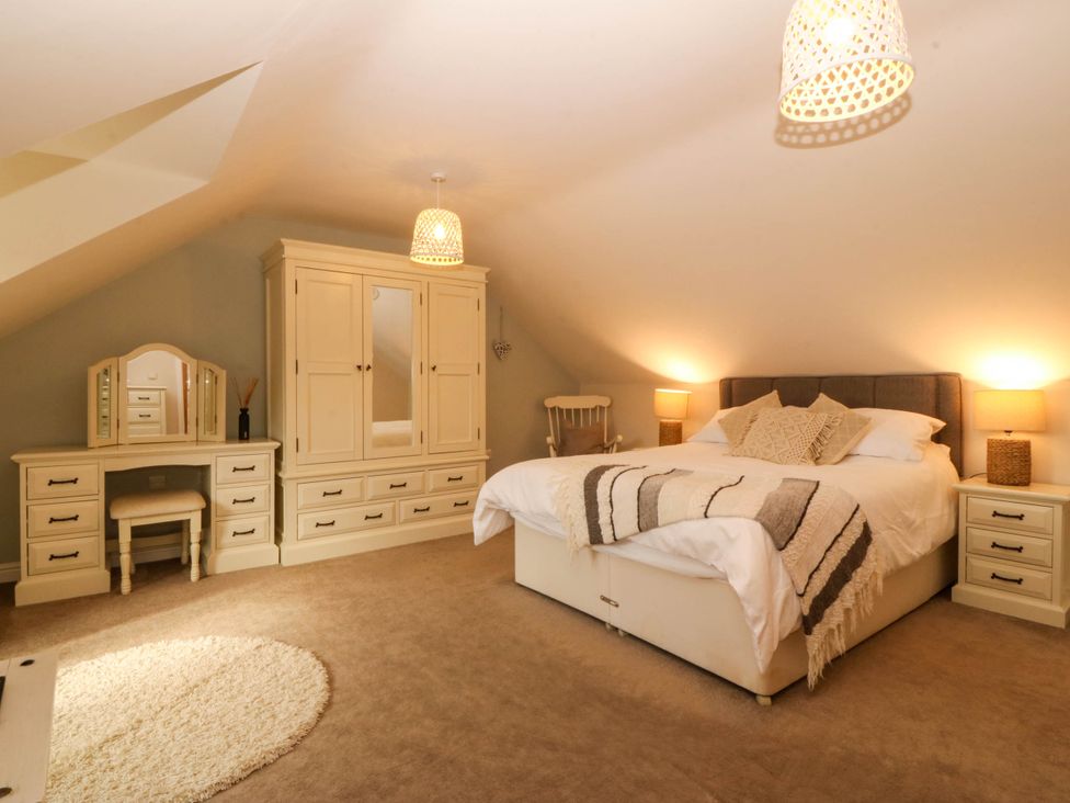 A bedroom with a bed and wardrobe at Ty Ni in Dyffryn Ardudwy