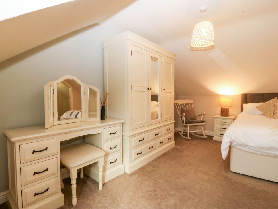 A bedroom with a mirror and dressing table at Ty Ni in Dyffryn Ardudwy