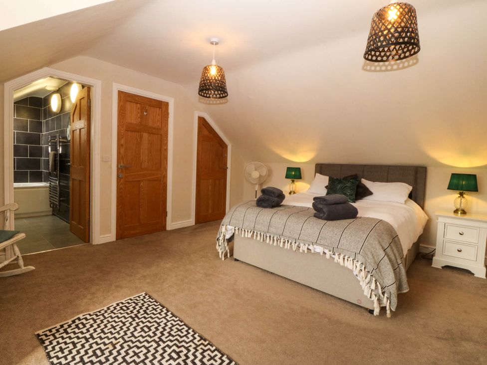 A bedroom with a bed and doors at Ty Ni in Dyffryn Ardudwy