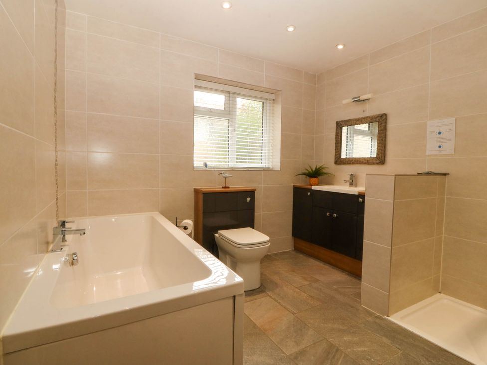 A bathroom featuring a bathtub, toilet, sink, and shower at Ty Ni in Dyffryn Ardudwy