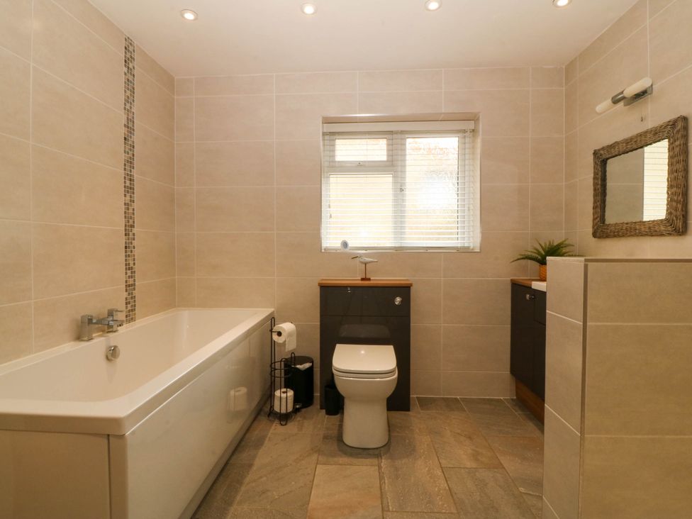 A bathroom with a bathtub, toilet, and sink at Ty Ni in Dyffryn Ardudwy