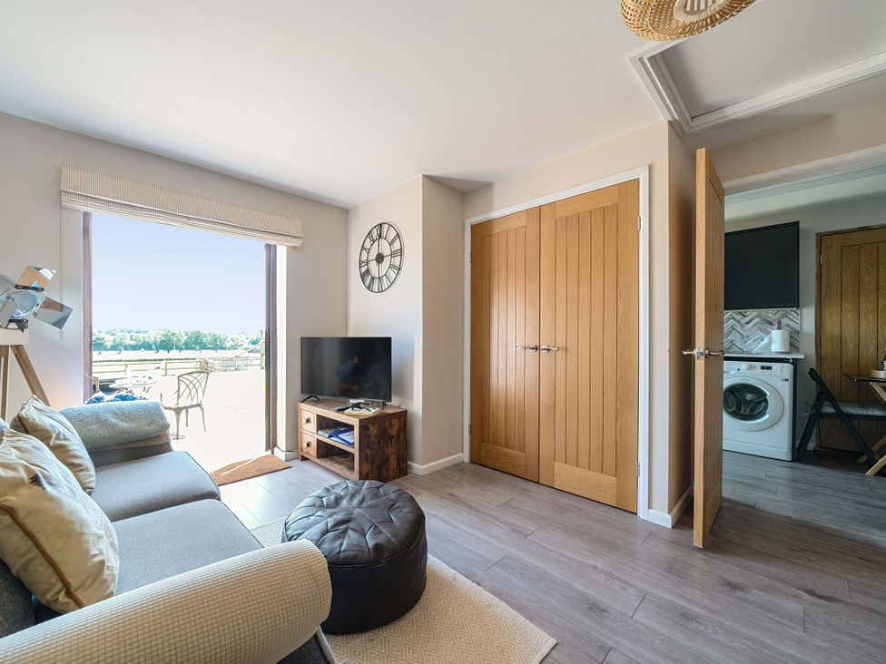 A living room with a sofa and television at Piglet Corner in Culmstock