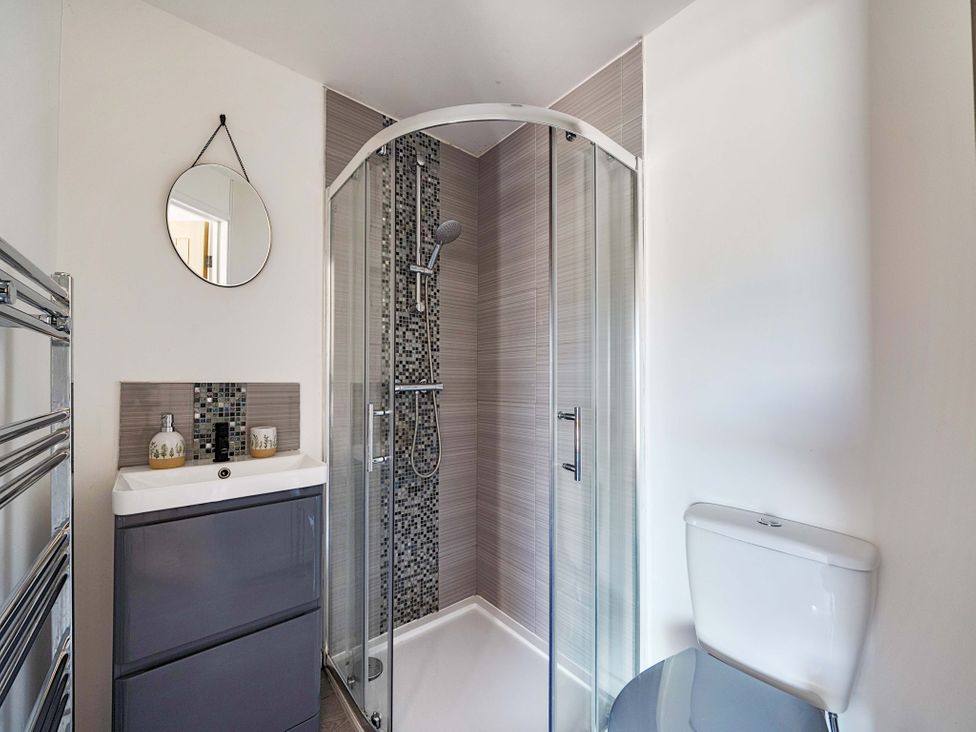 A bathroom with a shower, toilet, and sink at Piglet Corner in Culmstock