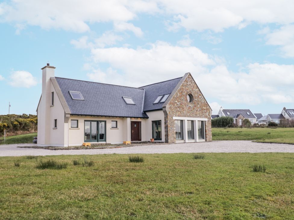 A house with a stone facade and a gravel driveway at Cashelrehine in Falcarrheh