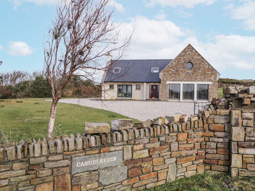 A house with a gravel driveway and stone wall at Cashelrehin in Falcarrheh