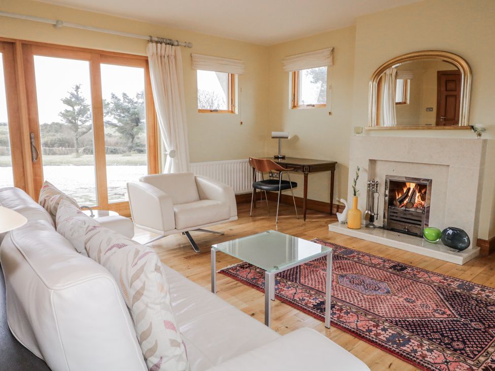 A living room with a fireplace and seating at Cashelrehine in Falcarrheh