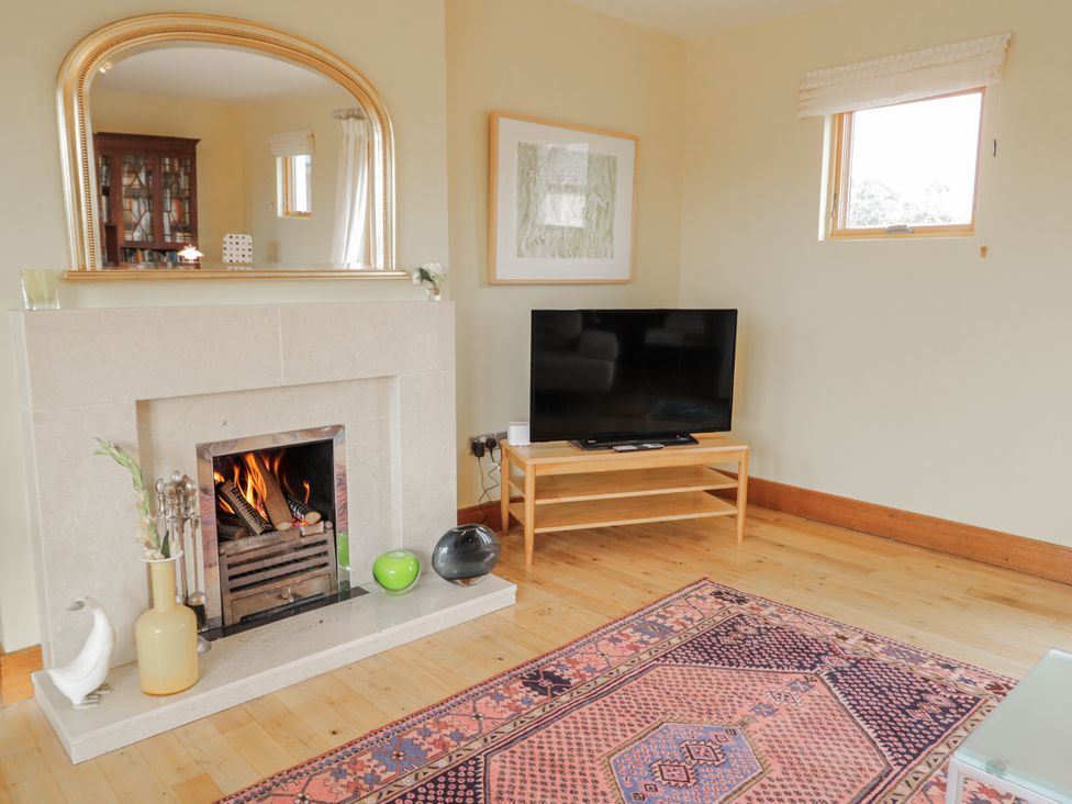 A living room with a fireplace and television at Cashelrehine in Falcarrheh