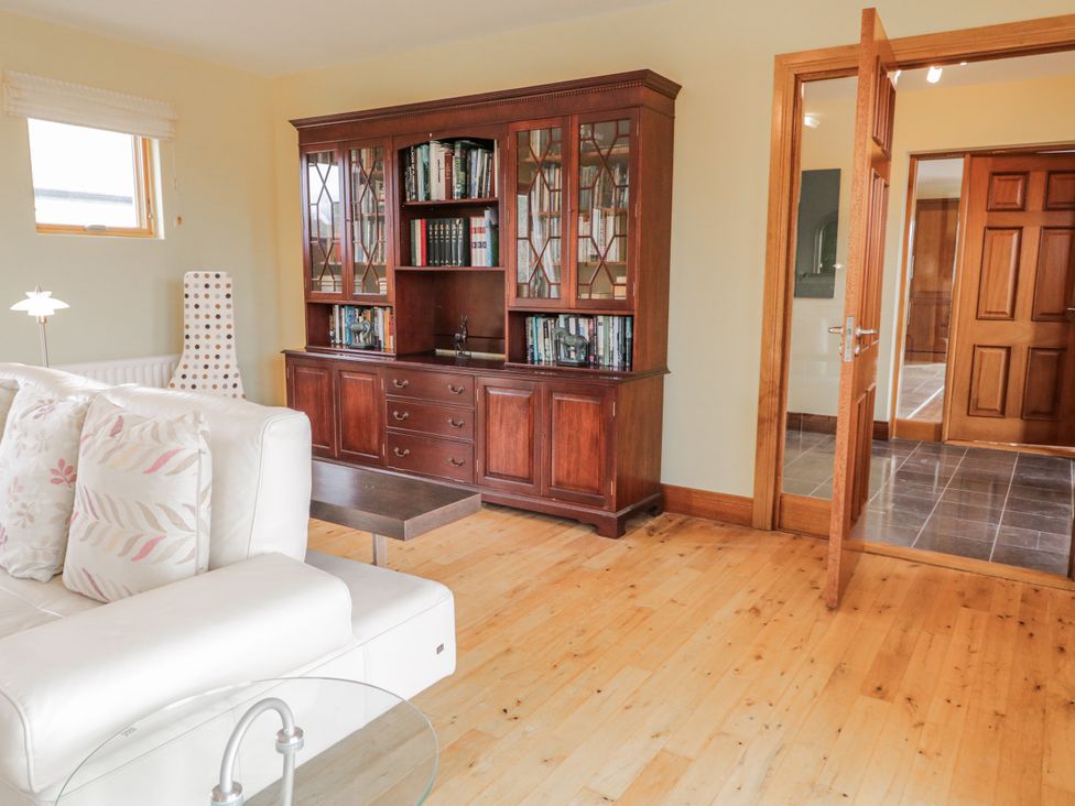 A living room with a bookshelf and sofa at Cashelrehine in Falcarrheh
