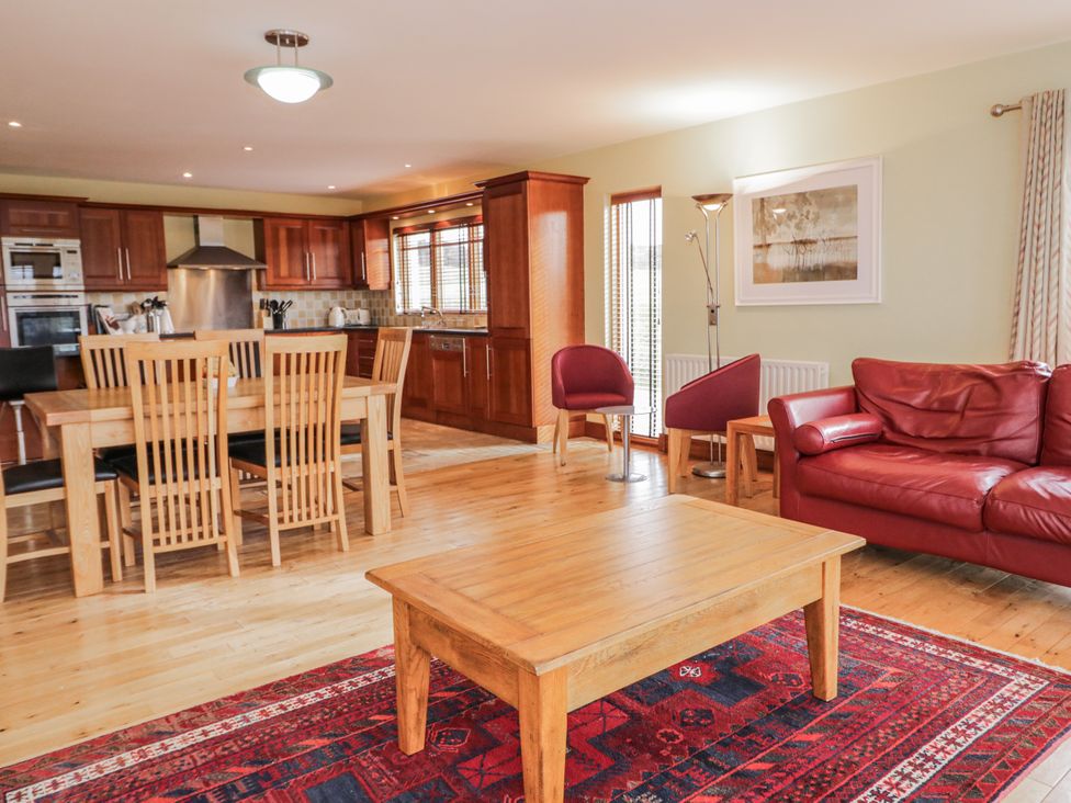 A dining area with a table and chairs and a living area with a sofa at Cashelrehine Falcarrheh
