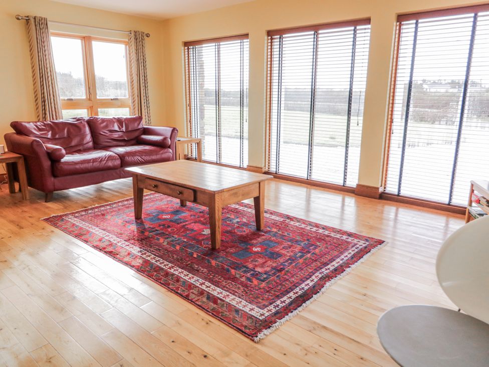 A living room with a sofa and table at Cashelrehine Falcarrheh