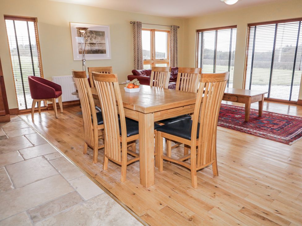 A dining room with a wooden table and chairs at Cashelrehine in Falcarrheh