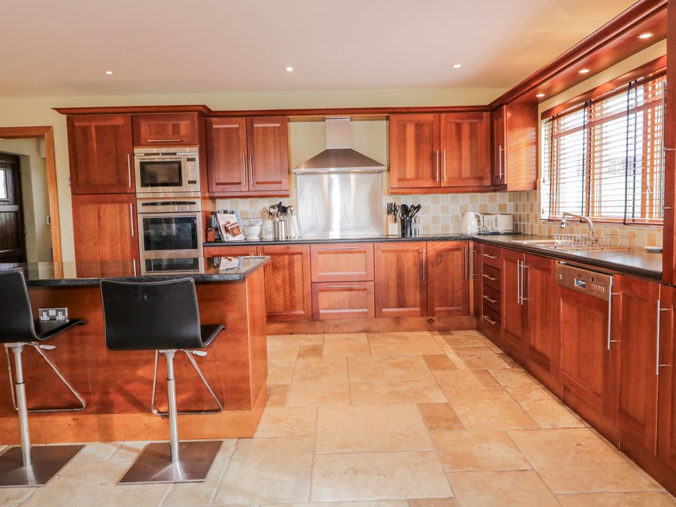 A kitchen with wooden cabinets and appliances at Cashelrehine in Falcarrheh
