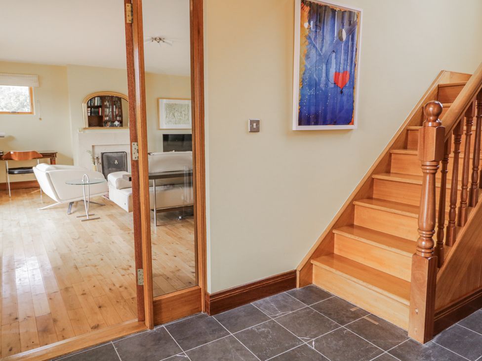 An entrance hall with a staircase and furniture at Cashelrehine in Falcarrheh
