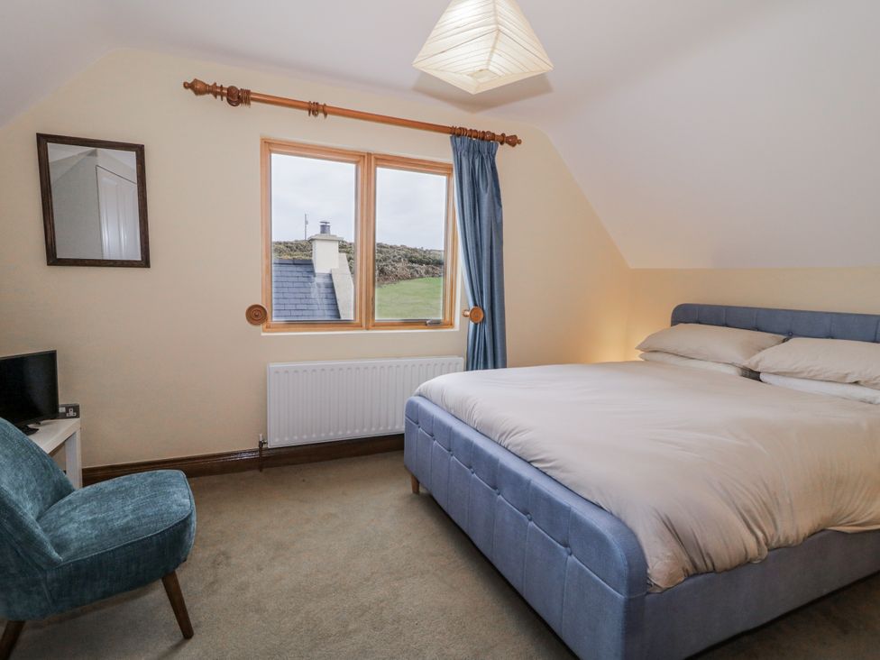 A bedroom with a bed and chair at Cashelrehine Falcarrheh