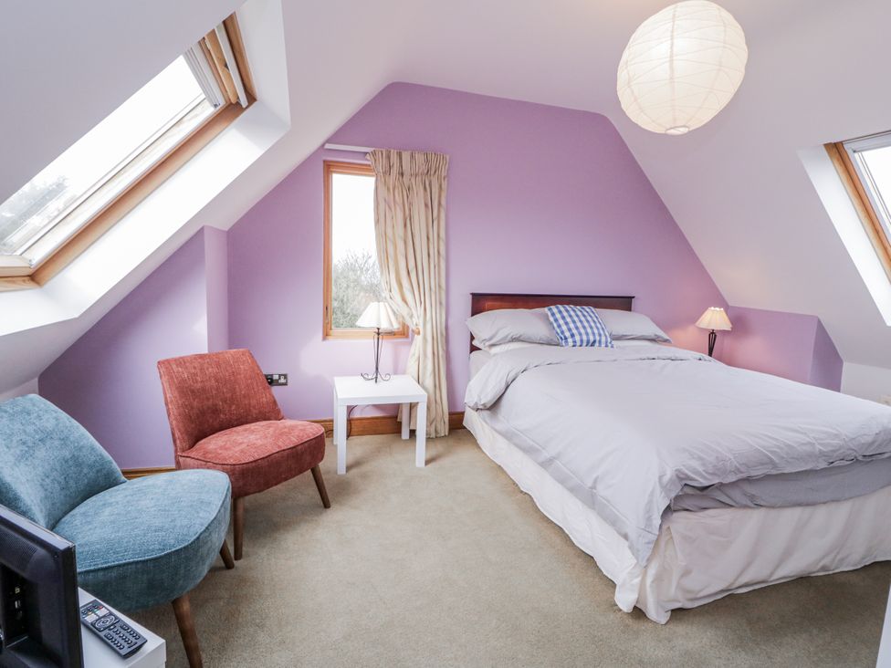 A bedroom with a bed and armchair at Cashelrehine, Falcarrheh