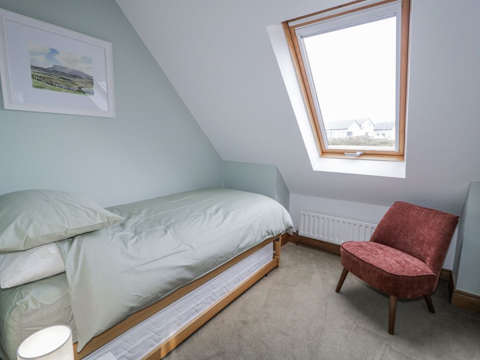 A bedroom with a single bed and a chair at Cashelrehine Falcarrheh