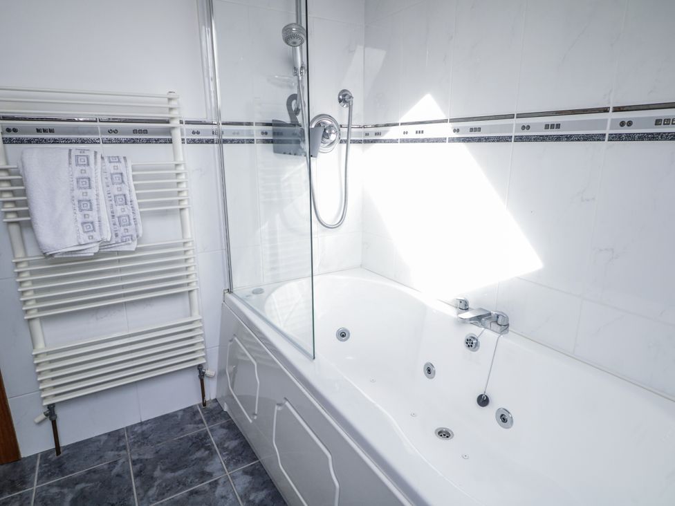 A bathroom with a bathtub and towel rack at Cashelrehine in Falcarrheh