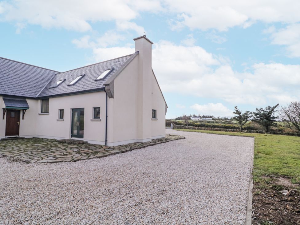 A house with a gravel driveway and garden at Cashelrehine Falcarrheh