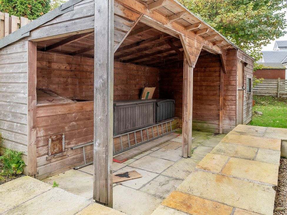 A garden shed with a bench and ladder at Taighean Anndra in Killin