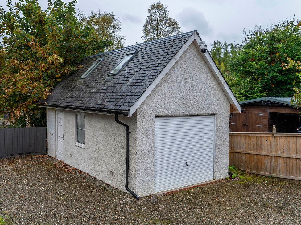 A garage with a white door and windows at Taighean Anndra in Killin