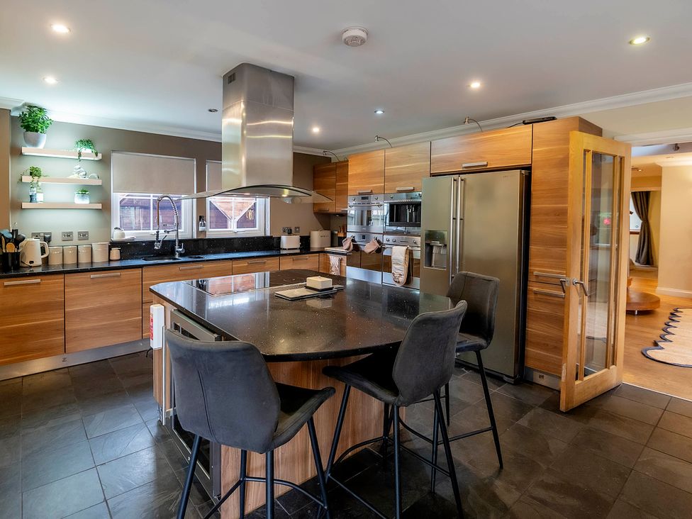 A kitchen with an island and stools at Taighean Anndra in Killin