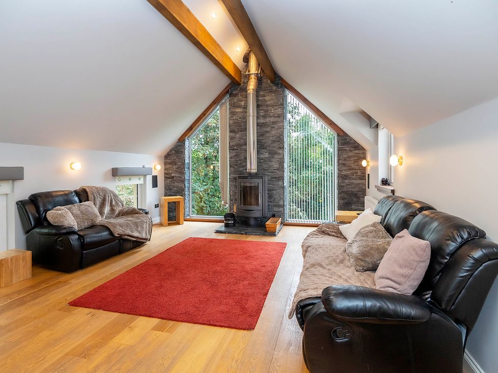 A living room with a fireplace and sofas at Taighean Anndra in Killin