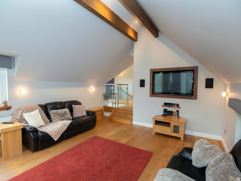 A living room with a sofa and television at Taighean Anndra in Killin