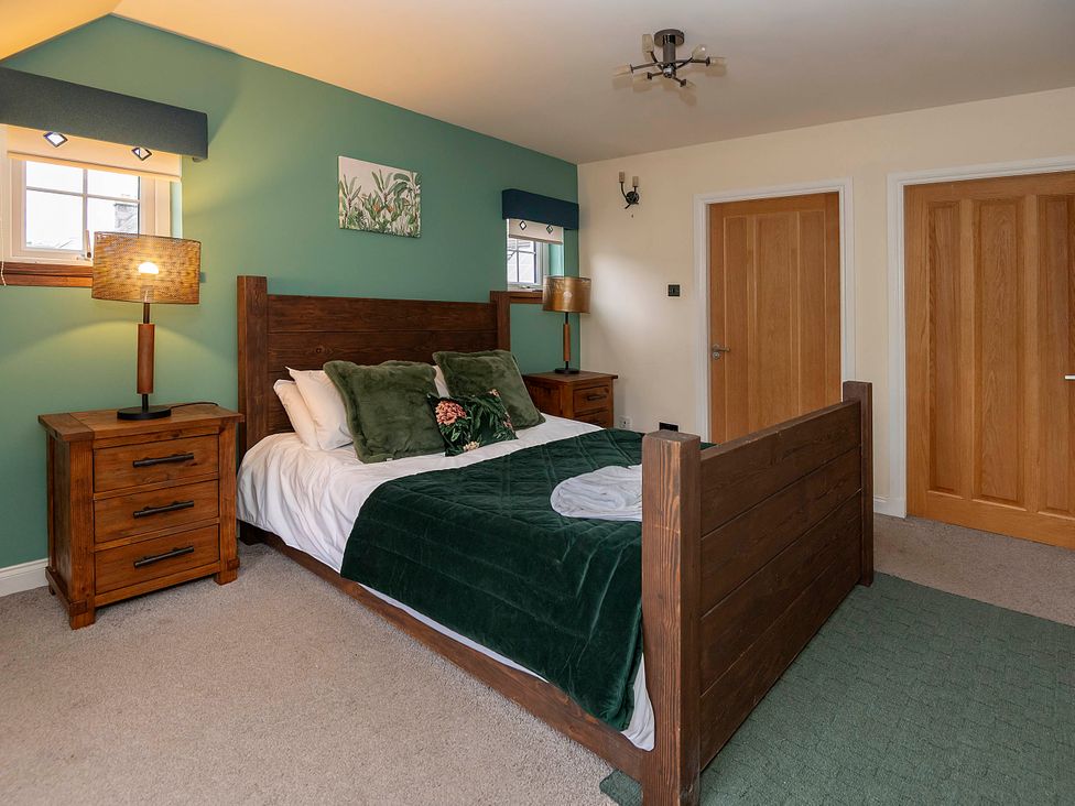 A bedroom with a bed and bedside table at Taighean Anndra in Killin
