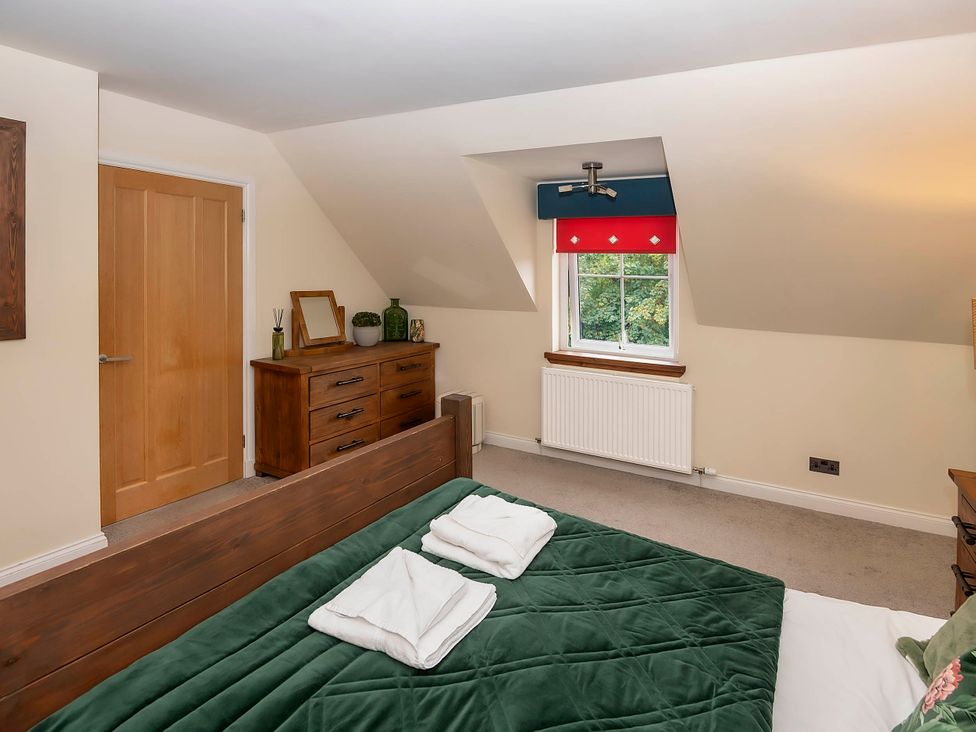 A bedroom with a bed and dresser at Taighean Anndra in Killin