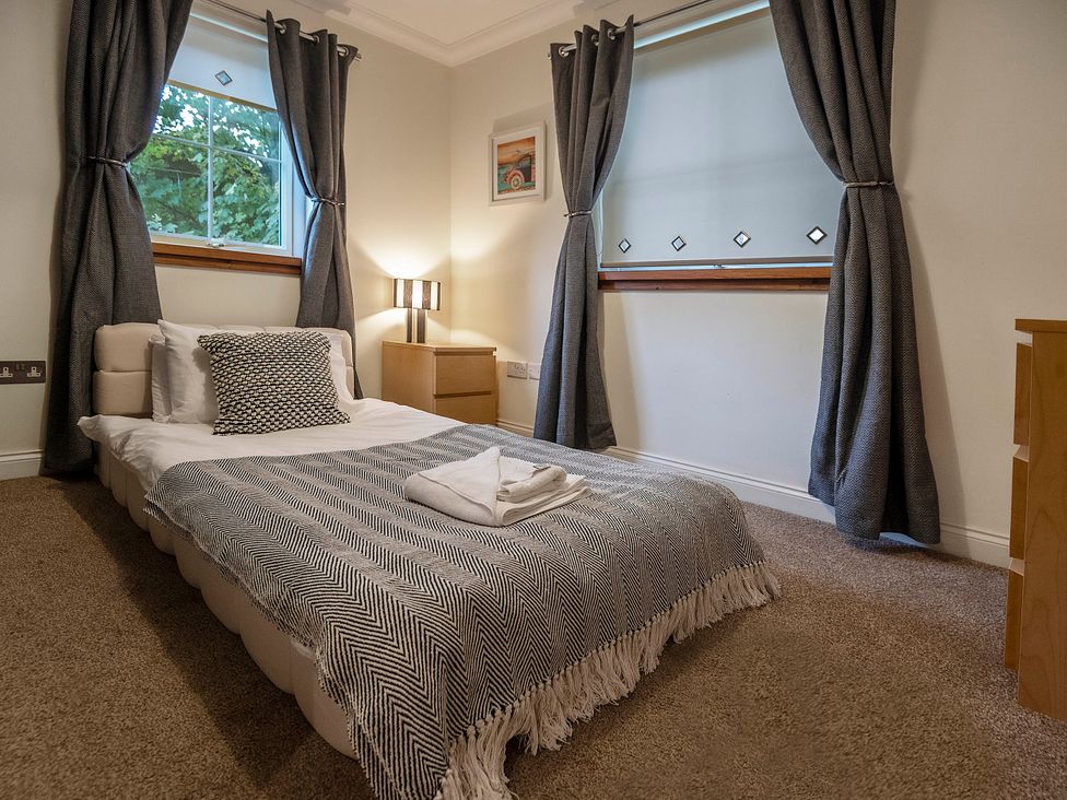 A bedroom with a bed and lamp at Taighean Anndra in Killin