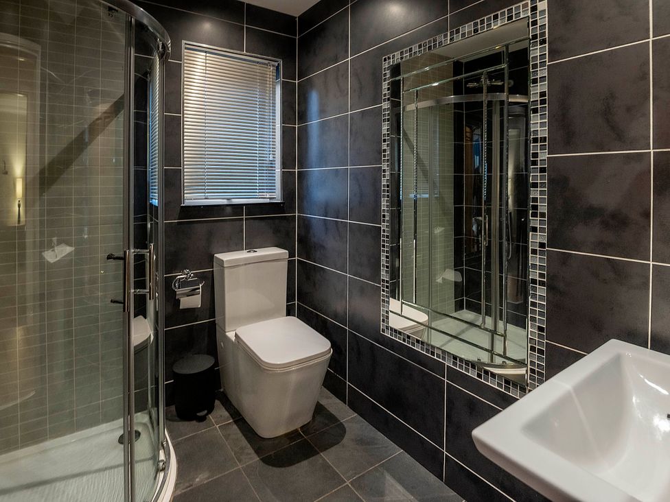 A bathroom with a shower, toilet, and sink at Taighean Anndra in Killin