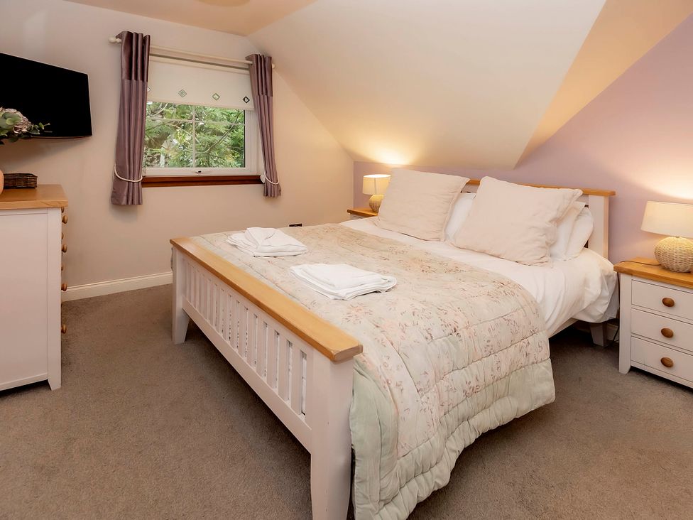 A bedroom with a bed and dresser at Taighean Anndra in Killin
