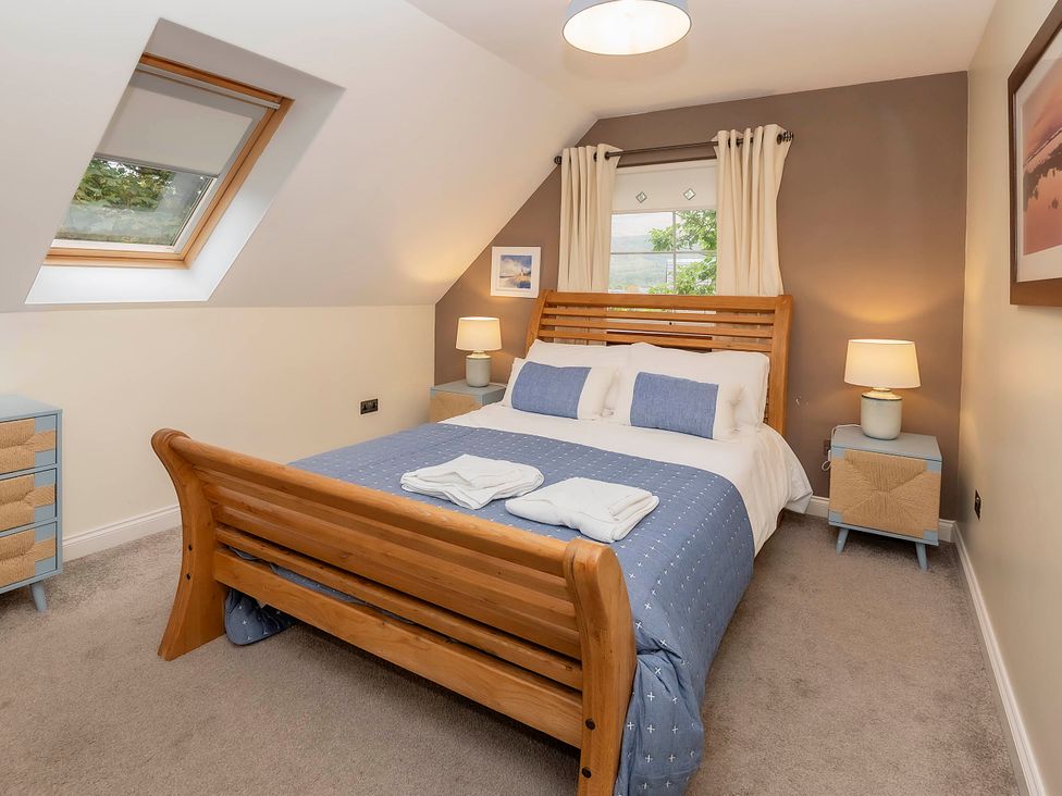 A bedroom with a bed and bedside tables at Taighean Anndra in Killin