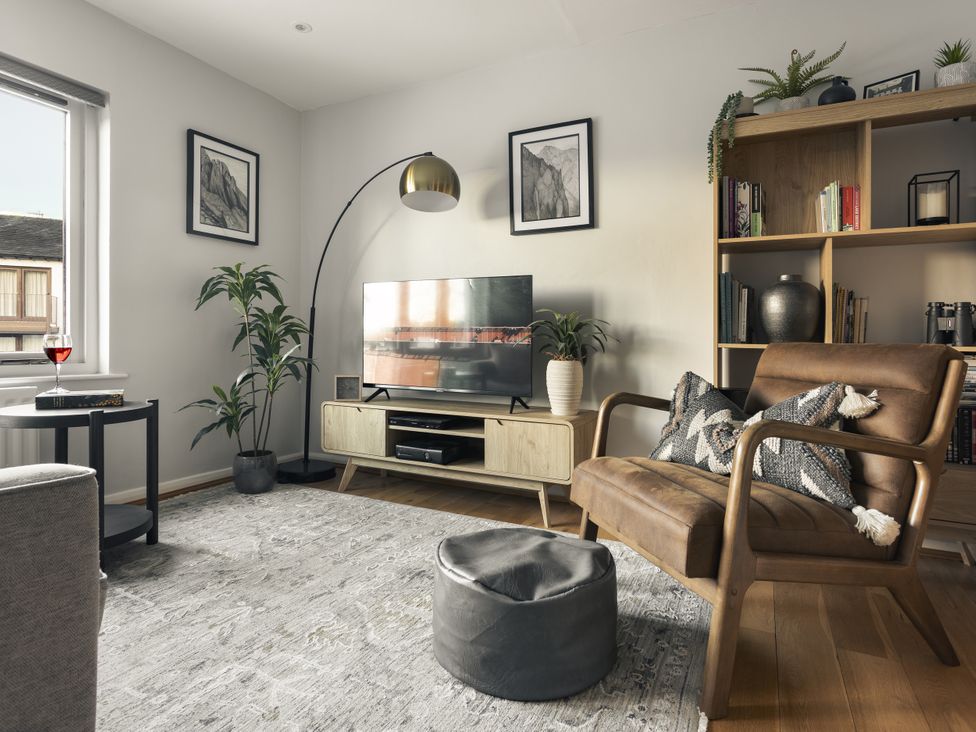 A living room with a television and a chair at Rydal Apartment Ambleside Ambleside