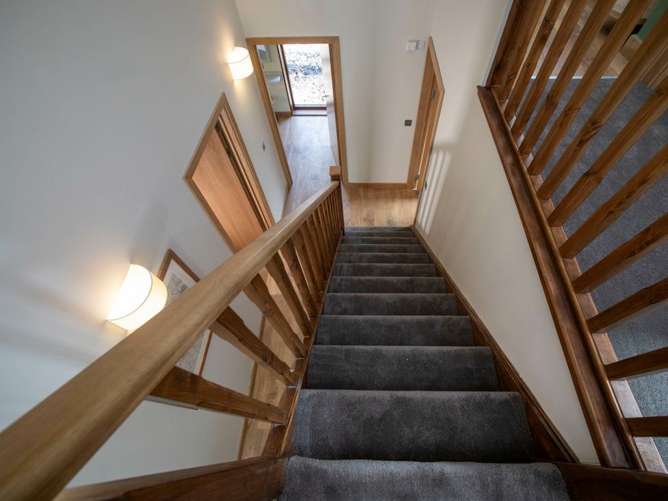 A staircase with wooden railings and a door leading outside at Strathyre Golden Oak Lochside Strathyre, Ben Ledi