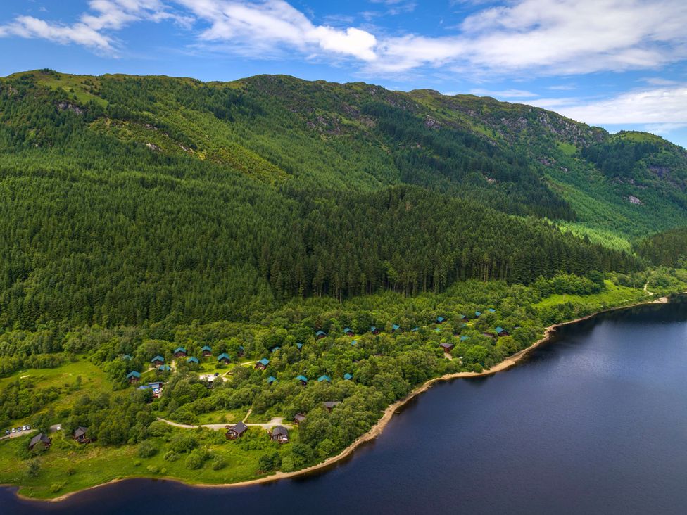 An aerial view of cabins along a lake surrounded by forest at Strathyre Golden Oak Lochside Strathyre, Ben Ledi