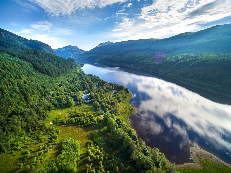 An aerial view of a lake surrounded by mountains and greenery at Strathyre Golden Oak Lochside Strathyre, Ben Ledi