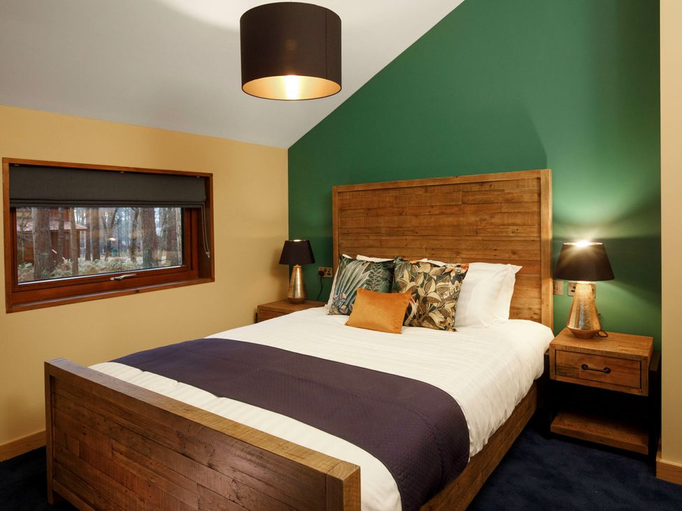 A bedroom with a bed and bedside tables at Delamere Forest Golden Oak Hideaway, Delamere Forest