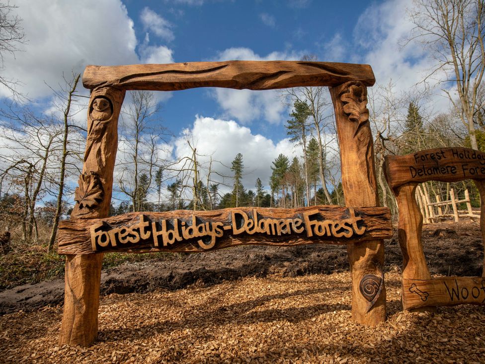 A wooden sign for Forest Holidays in Delamere Forest