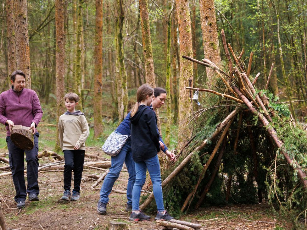 A group of people building a structure in a forest at Delamere Forest Golden Oak Hideaway Delamere Forest