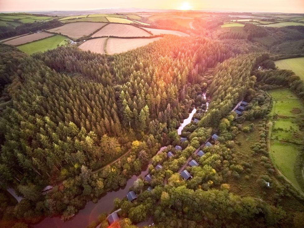 An aerial view of a forest with a river and cabins at Deerpark Classic Golden Oak Waterside Deerpark Forest