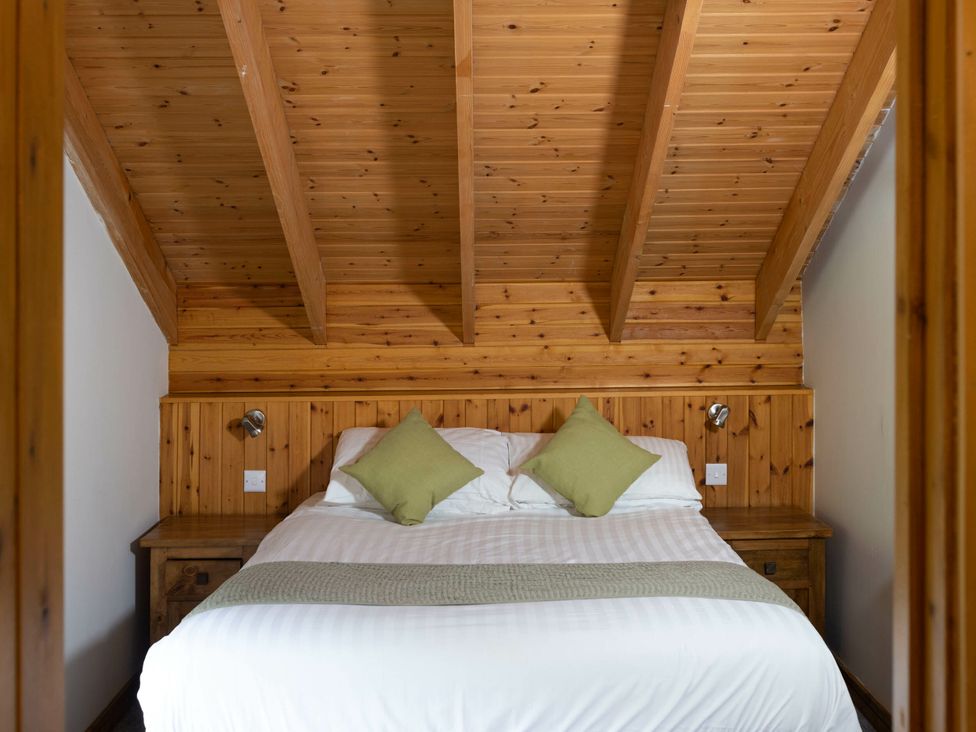 A bedroom with a bed and wooden features at Deerpark Classic Golden Oak Waterside Deerpark Forest