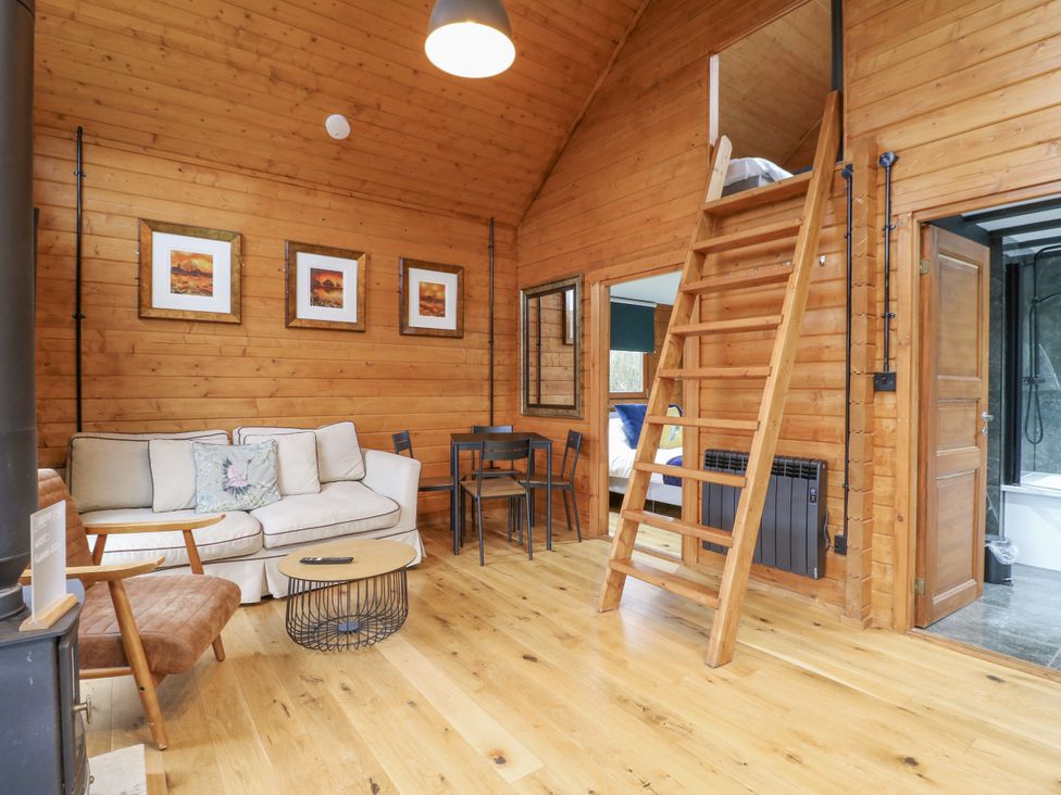 A living room with sofa and dining table at Squirrel's Nest in South Luffenham near Edith Weston