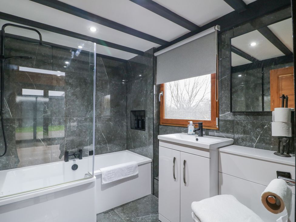 A bathroom with a bathtub, sink, and toilet at Squirrel's Nest in South Luffenham near Edith Weston