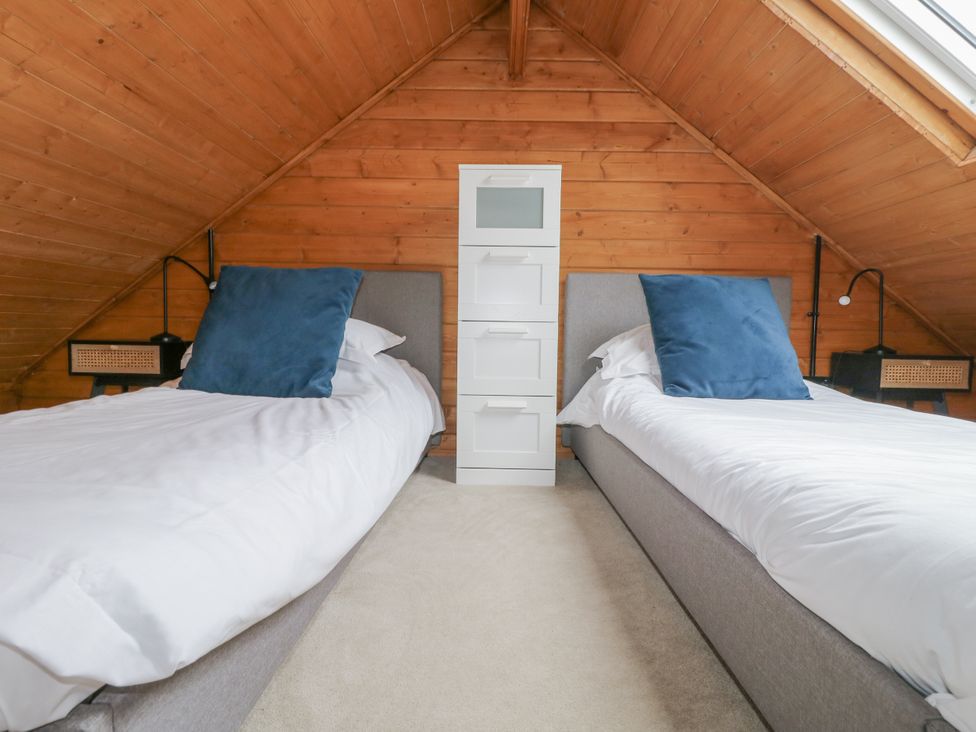 A bedroom with two beds and storage drawers at Squirrel's Nest South Luffenham near Edith Weston