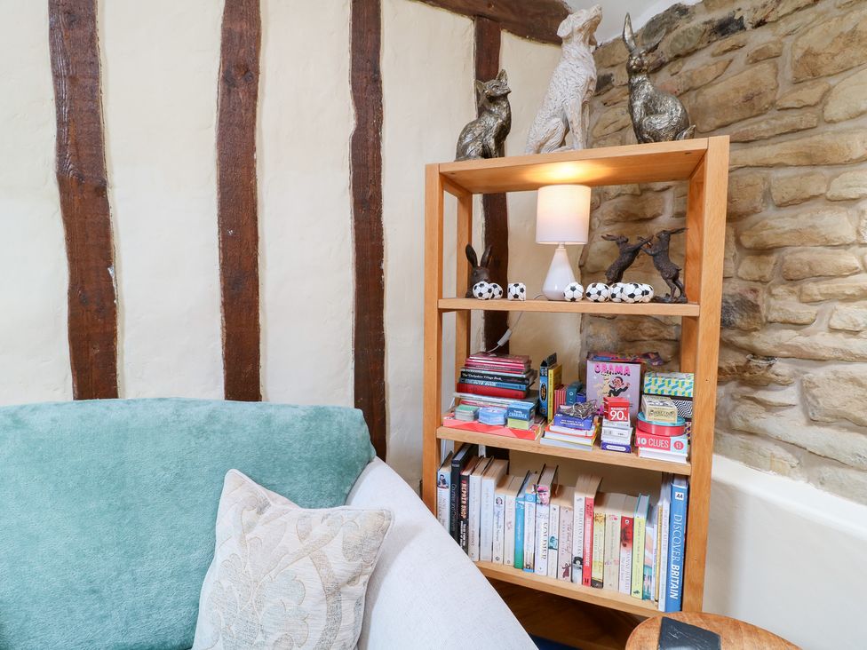 A snug with a shelf and books next to a sofa at 33 Main Road in Higham Derbyshire